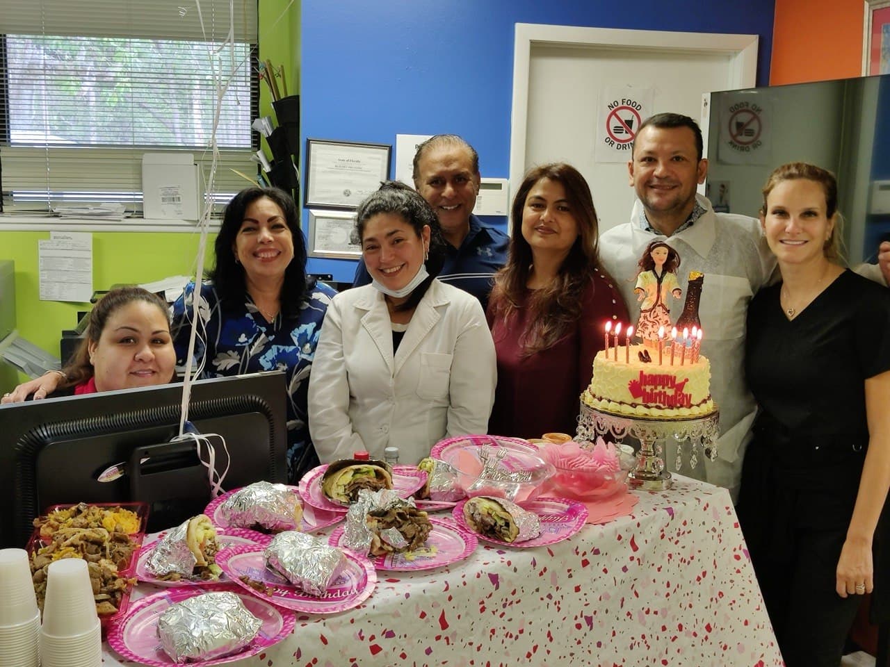 Lake Nona Medical Services team gathered around a birthday cake spread in the office