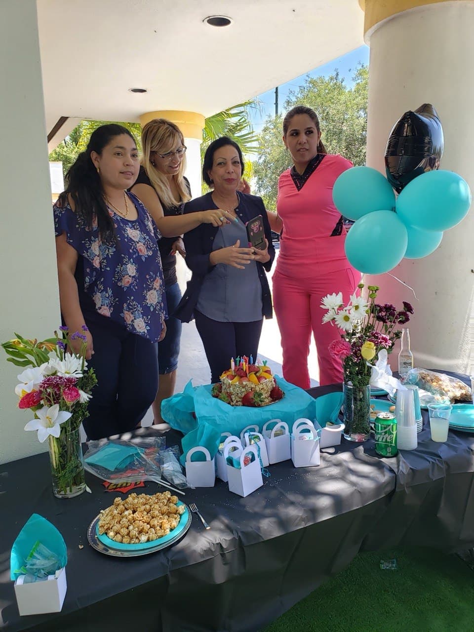 Outdoor team event with birthday cake and balloons